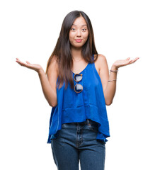 Young asian woman over isolated background clueless and confused expression with arms and hands...