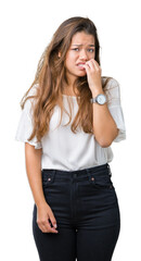 Fototapeta premium Young beautiful brunette business woman over isolated background looking stressed and nervous with hands on mouth biting nails. Anxiety problem.