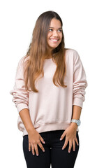 Young beautiful brunette woman wearing pink sweatshirt over isolated background looking away to side with smile on face, natural expression. Laughing confident.