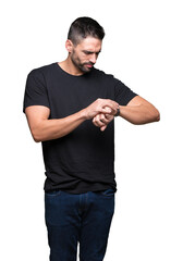 Young handsome man over isolated background Checking the time on wrist watch, relaxed and confident