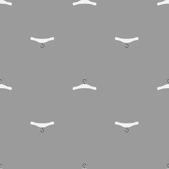 Seamless pattern of white hangers on a gray background