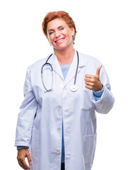 Senior caucasian doctor woman wearing medical uniform over isolated background doing happy thumbs up gesture with hand. Approving expression looking at the camera with showing success.