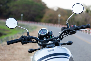 Motorcycle handlebars, mirrors, and speedometer view. Road view from vintage motorcycle. Bike theme...