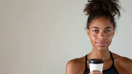 A female athlete with a coffee cup, exuding confidence against a neutral backdrop, providing room for customizable text or graphics 