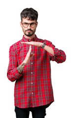 Young handsome man wearing glasses over isolated background Doing time out gesture with hands,...