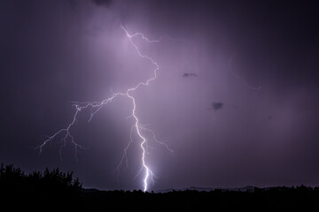 Powerful lightning strike in a bright purple sky
