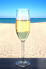 Glass of champagne on the wooden table in the beach bar. Picturesque background with sand and sea. Glassware Flute. 3d rendering.