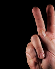 hand showing ok sign. Close-up a man's hand showing victory sign  in dark
