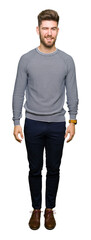 Young handsome man wearing stripes sweater winking looking at the camera with sexy expression,...