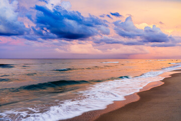 sunset over beach with waves crashing in ocean