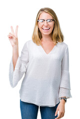 Beautiful young woman wearing glasses over isolated background smiling with happy face winking at the camera doing victory sign. Number two.