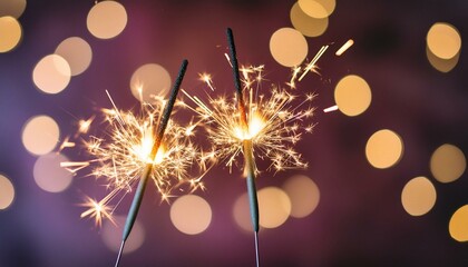 Fototapeta premium two classic sparklers with purple blurred bokeh lights on a black purple gradient background