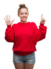 Young blonde woman wearing bun and red sweater showing and pointing up with fingers number six while smiling confident and happy.