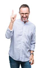 Fototapeta premium Middle age hoary senior man wearing glasses over isolated background pointing finger up with successful idea. Exited and happy. Number one.