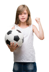 Young blonde toddler holding football ball annoyed and frustrated shouting with anger, crazy and yelling with raised hand, anger concept