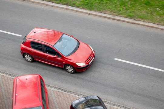 Red Peugeot 307 hatchback car with motion blur effect