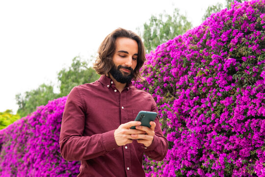 Man using smartphone in vibrant Poblenou park
