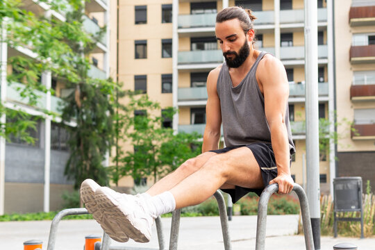 Man exercising on parallel bars in an urban park