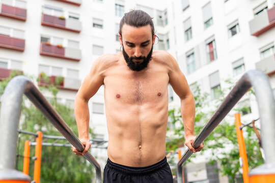 Man exercising on parallel bars in Poblenou neighborhood