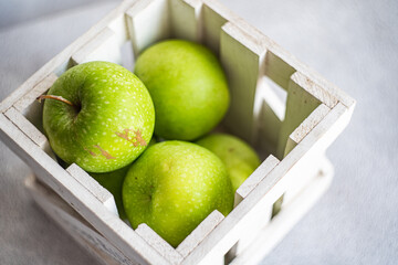 Fresh green apples in a white wooden crate