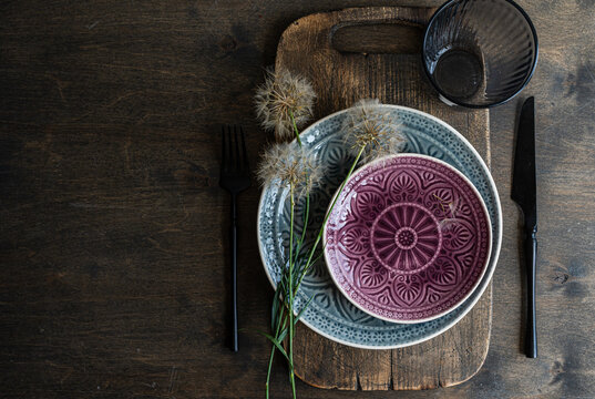 Rustic dining setting with dandelion and patterned ceramics