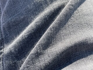Fototapeta premium Close-up of grey jeans clothing, showing folds in material
