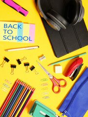 Zenith view, back to school, supplies, various accessories and  technology, in full color and yellow background. Vertical shot.