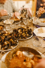 Tisch mit Tellern voller Muscheln und Weingläsern