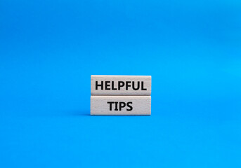 Helpful tips symbol. Wooden blocks with words Helpful tips. Beautiful blue background. Business and Helpful tips concept. Copy space.