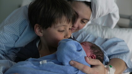 Family Welcomes Newborn at Hospital - Brother Holds Baby as Mother Looks On, Celebrating First Sibling Bonding