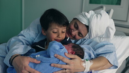 First Family Moments with Newborn in Hospital - Siblings bond as brother holds baby, mother looks...