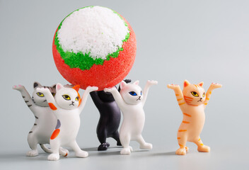 Toy kittens carry a large multi-colored bath bomb on their raised paws. A fun concept for teaching...