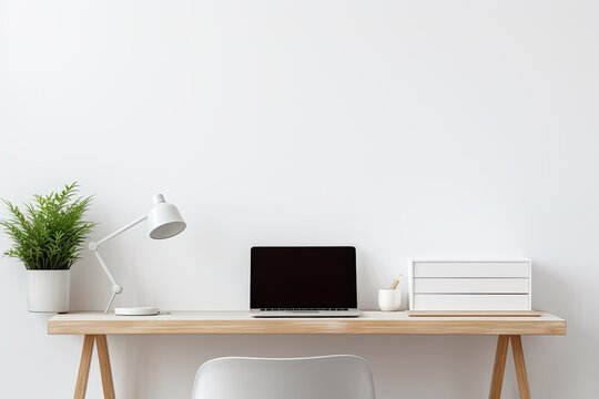 A white desk with a laptop and chair in front of a white wall.