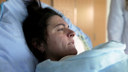 Postpartum Care in Hospital - New Mother Experiencing Discomfort with Newborn Baby in Arms, Medical...