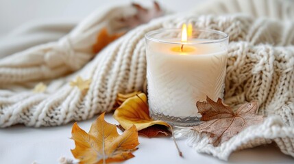 Cozy autumn home decor with candle and leaves on white background
