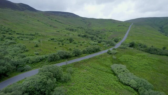 Aerial drone shot reveal of countryside house, flying over mountain shot, on the Isle Of Arran, Scotland