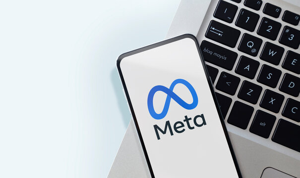 Meta logo on smartphone screen. Meta is the new name of the company that owns Facebook, WhatsApp and Instagram. Closeup of mobile phone over a laptop keyboard. Rosario, Argentina - June 21, 2024.