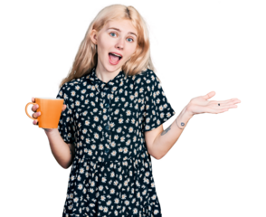 Young caucasian woman drinking a cup of coffee celebrating achievement with happy smile and winner expression with raised hand