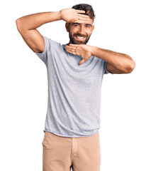 Young hispanic man wearing casual clothes smiling cheerful playing peek a boo with hands showing face. surprised and exited