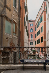 bench with letters gondola service on it in front of old historic buildings in Venice