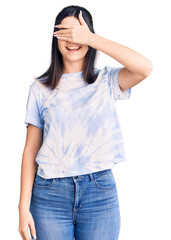 Young beautiful girl wearing casual t shirt smiling and laughing with hand on face covering eyes for surprise. blind concept.