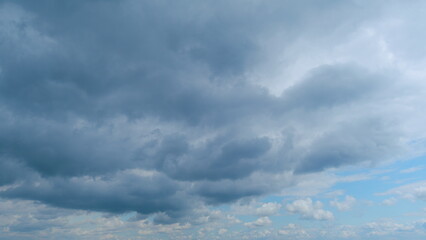 Obraz premium Dense thunderclouds dissolve in the sky, backlit by the sun. Sky storm cloud motion. Time lapse.