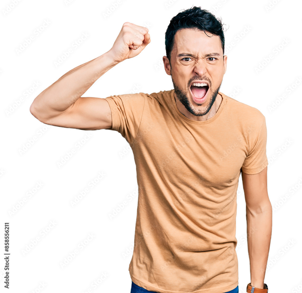 Canvas Prints Hispanic man with beard wearing casual t shirt angry and mad raising fist frustrated and furious while shouting with anger. rage and aggressive concept.