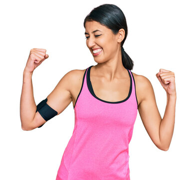 Beautiful asian young sport woman wearing sportswear and arm band showing arms muscles smiling proud. fitness concept.