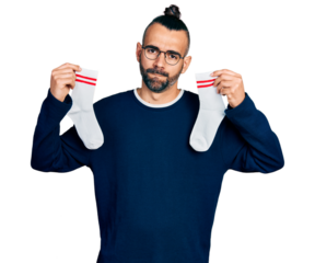 Hispanic man with ponytail holding socks skeptic and nervous, frowning upset because of problem. negative person.