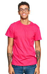 Young handsome african american man wearing casual clothes looking positive and happy standing and...
