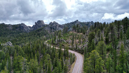 Winding road in rocky mountains. Drone shot, aerial photo of highway goes through the national park. Forest landscape