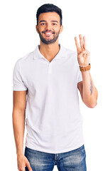 Young handsome hispanic man wearing casual clothes showing and pointing up with fingers number three while smiling confident and happy.