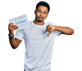 Young african american man holding rainy weather calendar with angry face, negative sign showing dislike with thumbs down, rejection concept