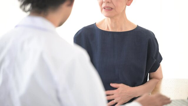 医師に体の不調を訴える高齢の患者　胃やお腹やのどのの痛みなど　顔無しの動画